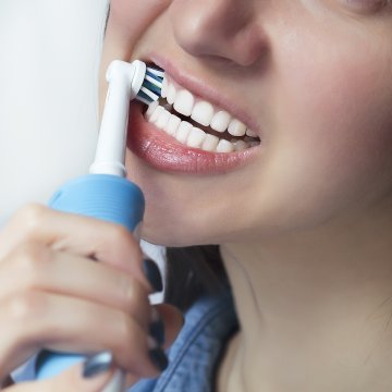 Person using electric toothbrush